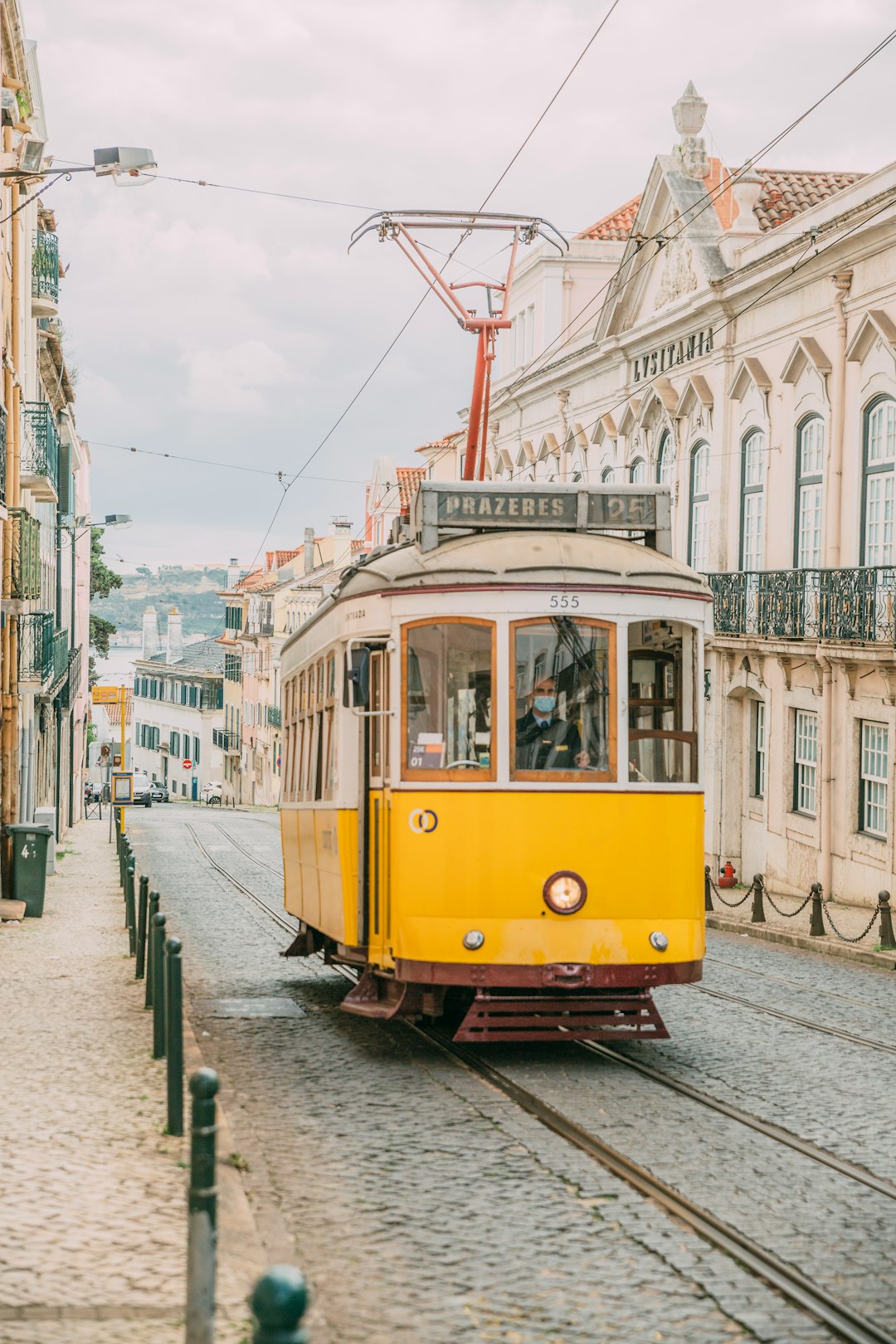 yellow and white tram on road near white concrete building during daytime