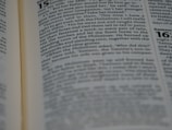 A close-up view of an open book, displaying printed text in paragraphs with a focus on a specific passage. The text is clear and in a serif font, indicating a formal or scholarly tone. One page is slightly out of focus, creating depth.