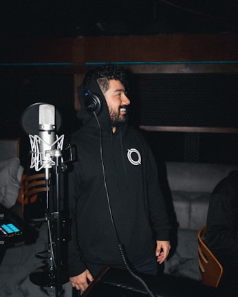 An artist celebrating the release of their new single on rw digital with headphones on, smiling in a cozy studio.