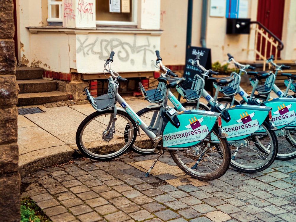 blaues und schwarzes Fahrrad tagsüber neben einer braunen Ziegelmauer geparkt