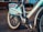 A close-up view of a rental bicycle, prominently displaying the branding 'Durstexpress.de'. The bike has a light blue frame with visible logos and text decals, including 'DING DONG!' and 'nextbike'. The bicycle is parked on a paved street with a blurred urban background.