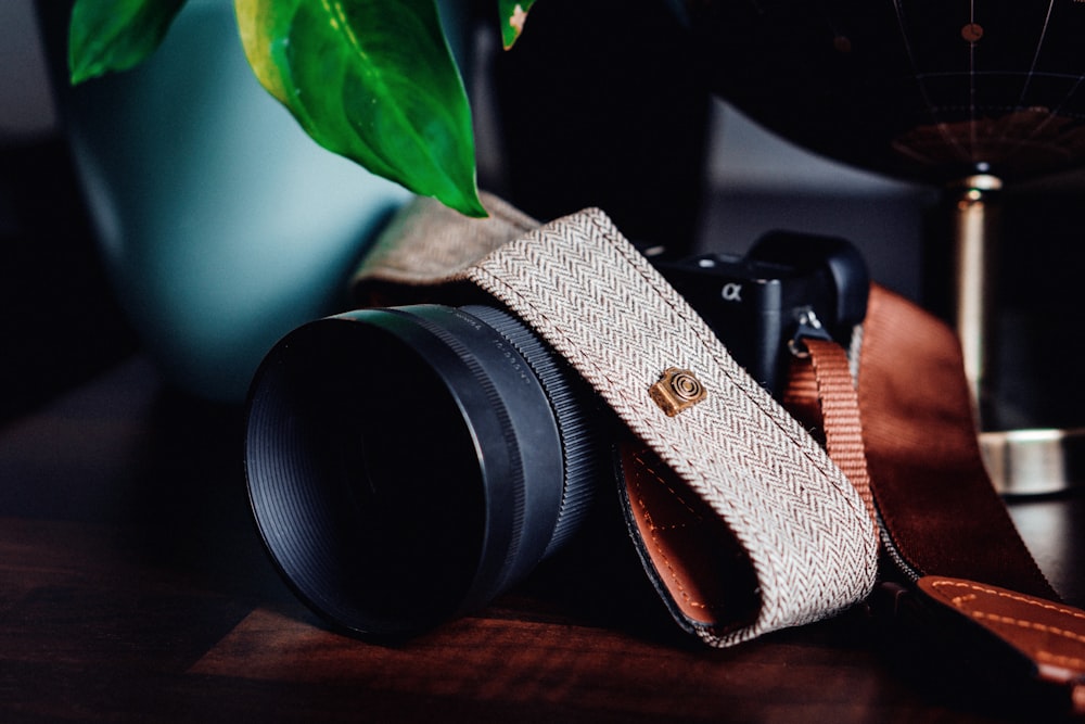 black and silver dslr camera on brown wooden table