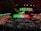 A large indoor conference venue filled with a seated audience. The stage is adorned with brightly colored digital displays in green and red, featuring the words 'Web Summit'. Multiple large screens project an image of a speaker addressing the crowd from the stage.