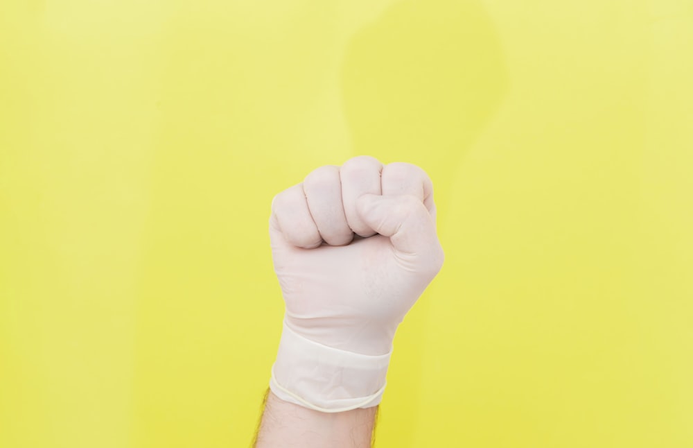 Person mit gelbem Papier in der Hand