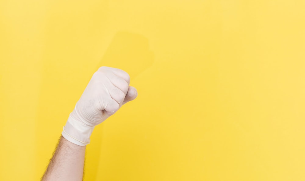 Person mit gelbem Papier in der Hand