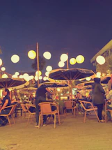 A cozy roadside warung at sunset with warm lights glowing, inviting conversation.