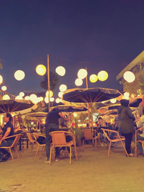 A cozy roadside warung at sunset with warm lights glowing, inviting conversation.