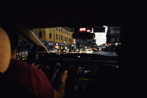 A sleek dashcam mounted on a car windshield capturing a vibrant cityscape at dusk.