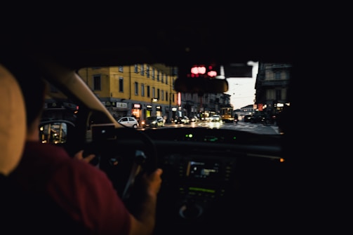 A sleek dashcam mounted on a car windshield capturing a vibrant cityscape at dusk.
