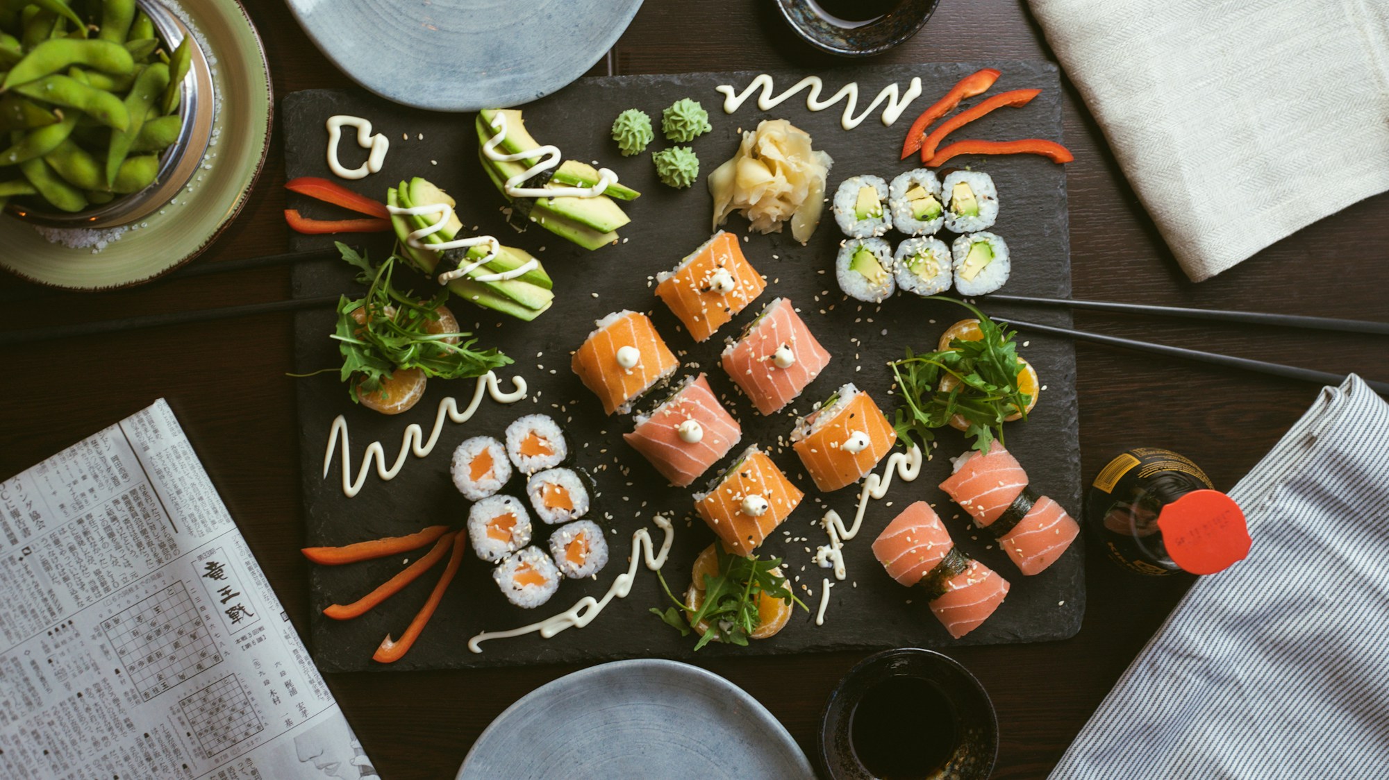 Assorted sushi arranged on a dark ceramic plate