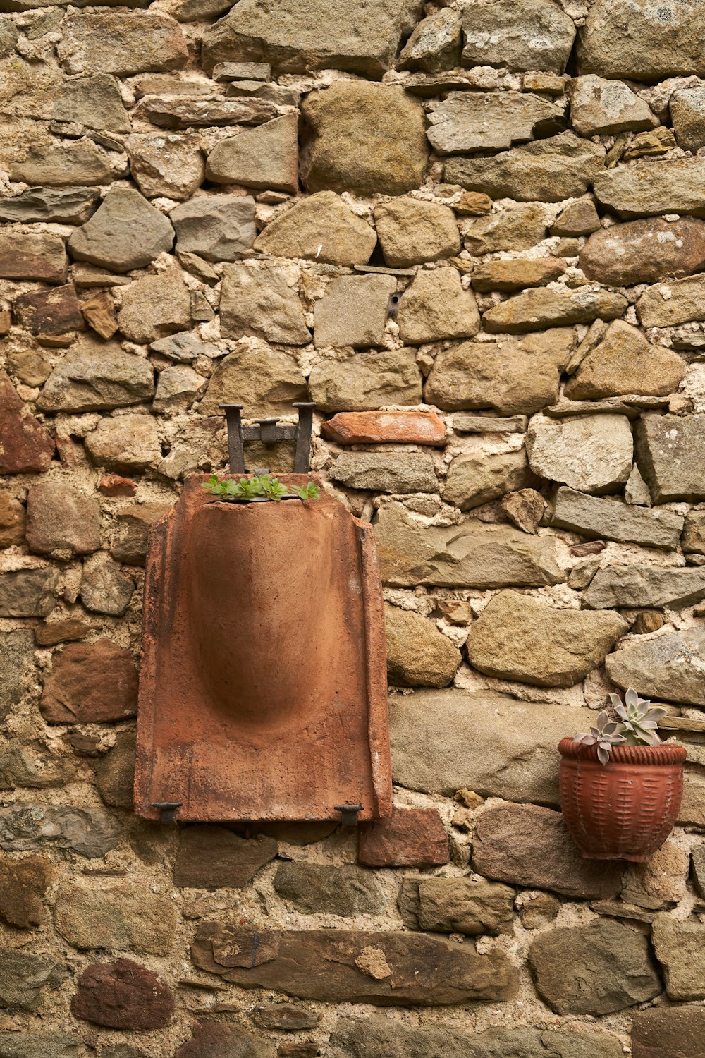 brown and green ceramic vase on brown concrete wall