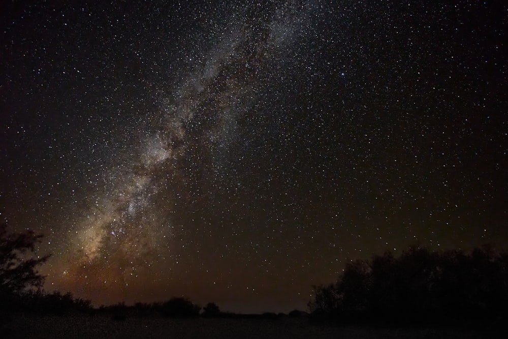 silhouette of mountain under starry night