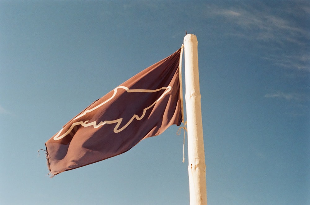 red and yellow flag on pole under blue sky during daytime