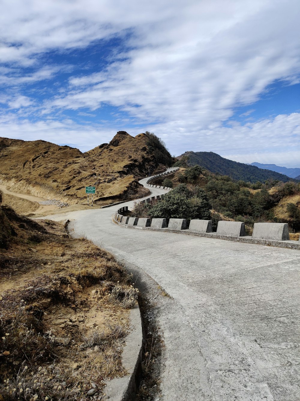 Auto sulla strada vicino alla montagna sotto il cielo blu durante il giorno