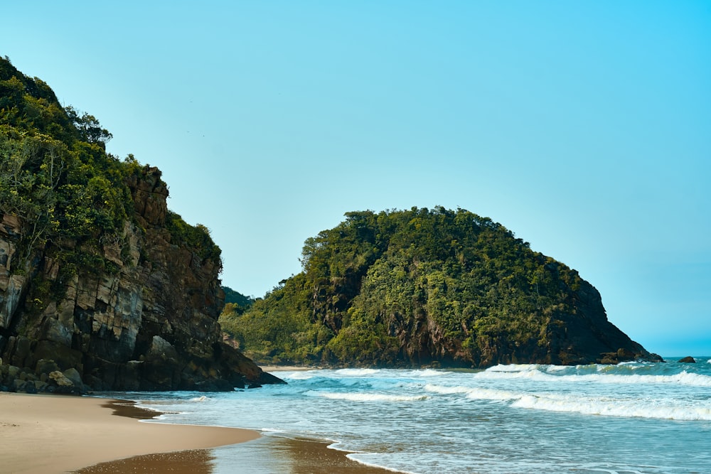 green and brown rock formation on sea shore during daytime