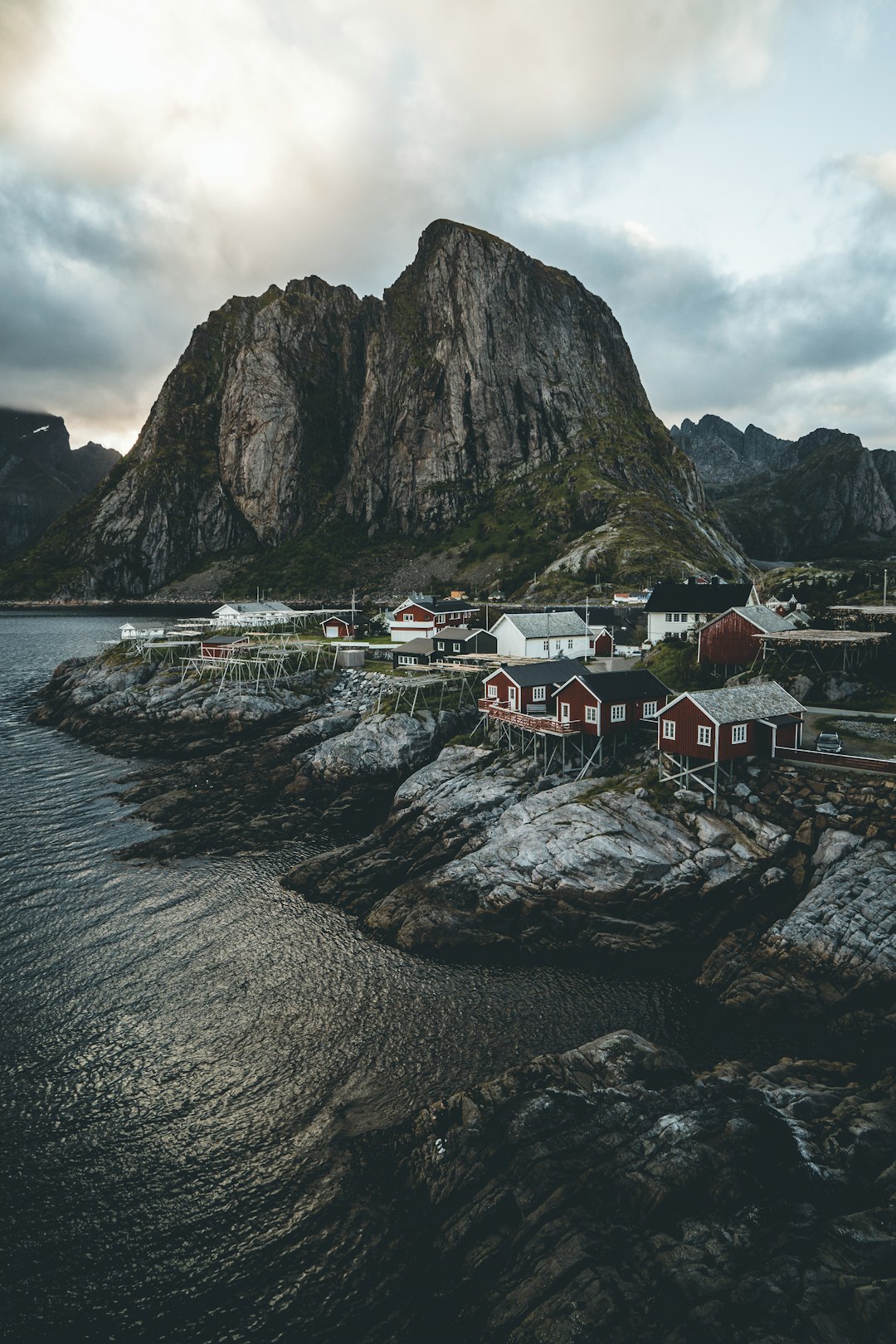 houses near body of water and mountain during daytime