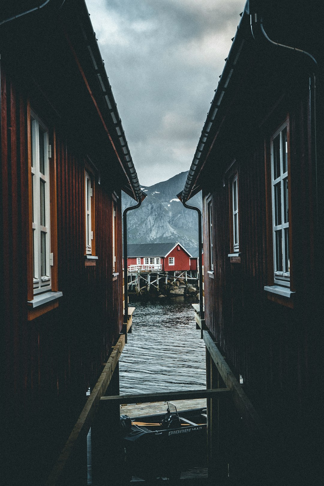 brown wooden houses on water under gray clouds