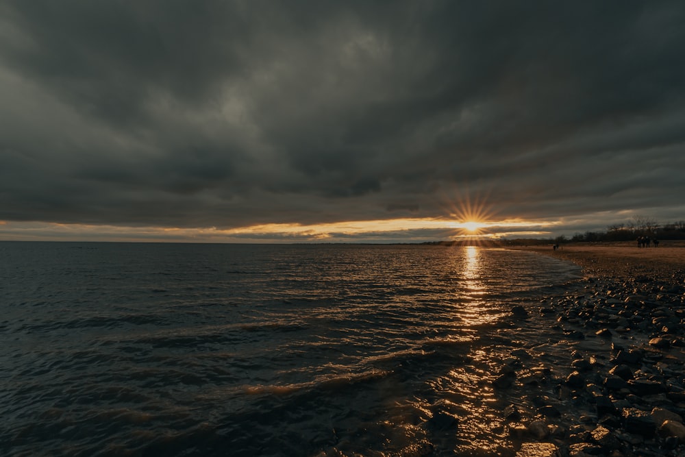 sea waves crashing on shore during sunset