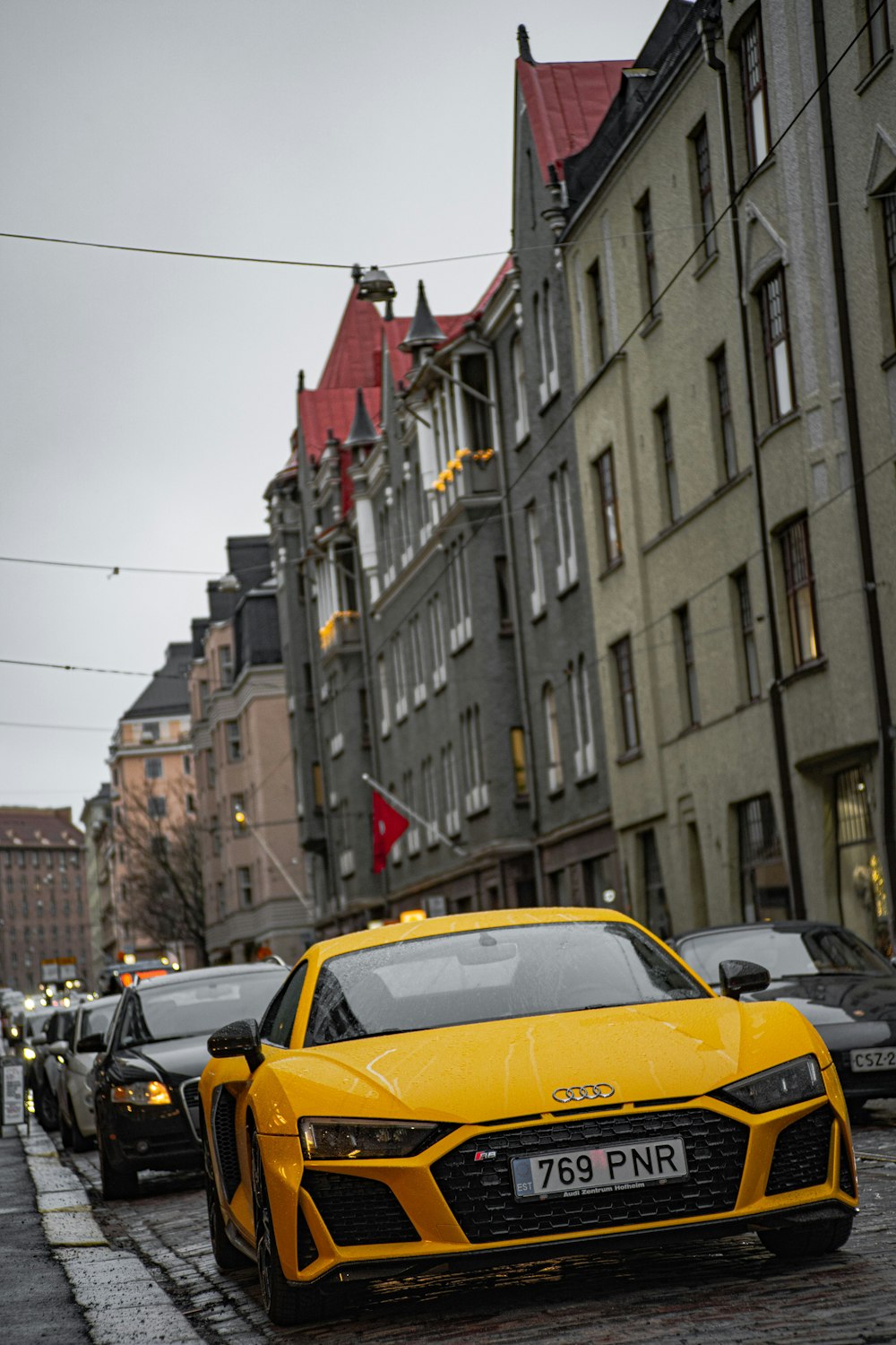 carro amarelo na estrada perto de edifícios durante o dia