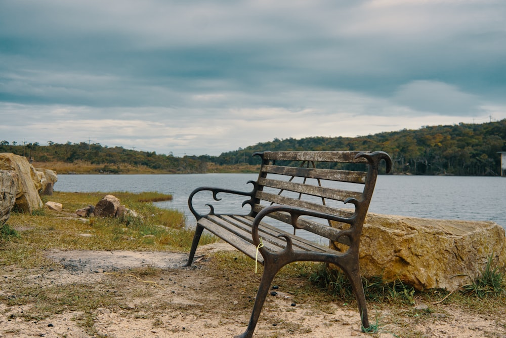 brown wooden bench on brown field under white clouds during daytime