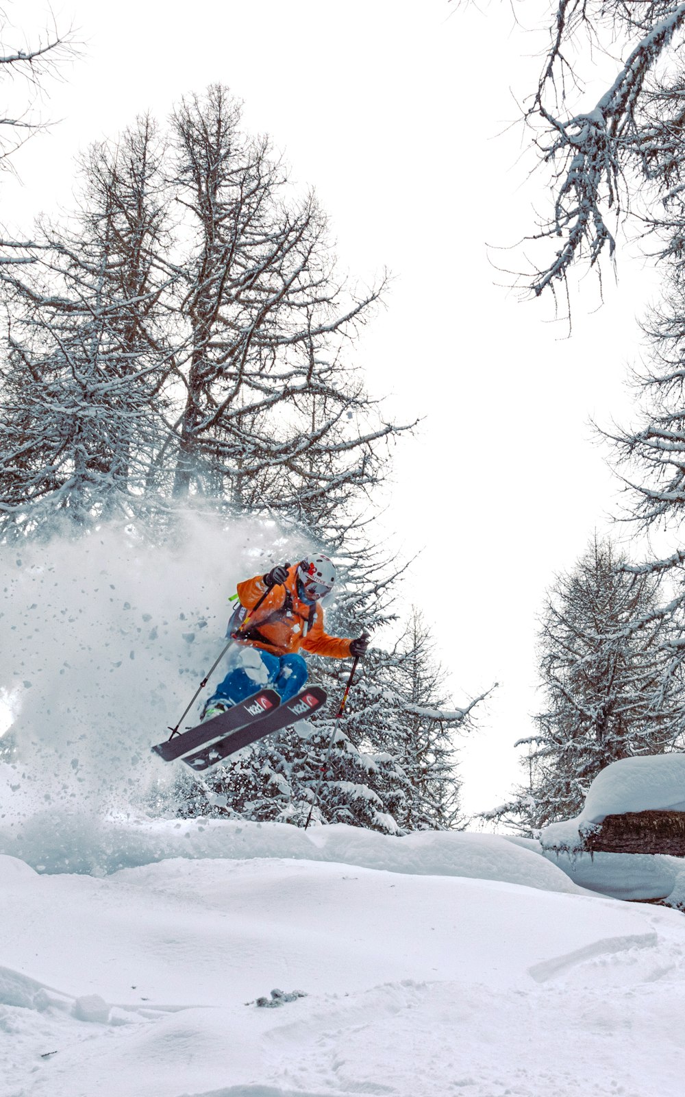 person in orange jacket riding snowboard on snow covered ground during daytime