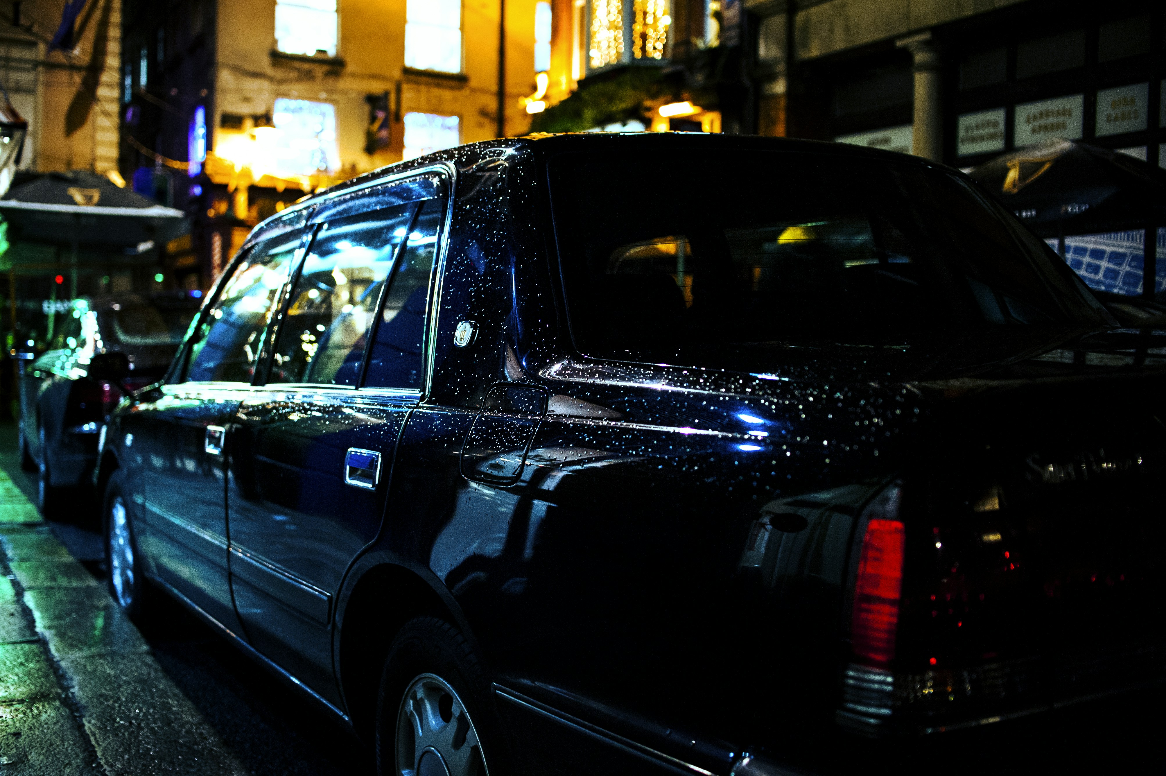 black suv parked on sidewalk during daytime