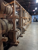 Golden coconut oil barrels reflecting light in a modern storage area.