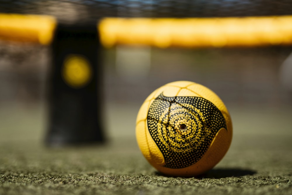 yellow and black soccer ball on green grass field