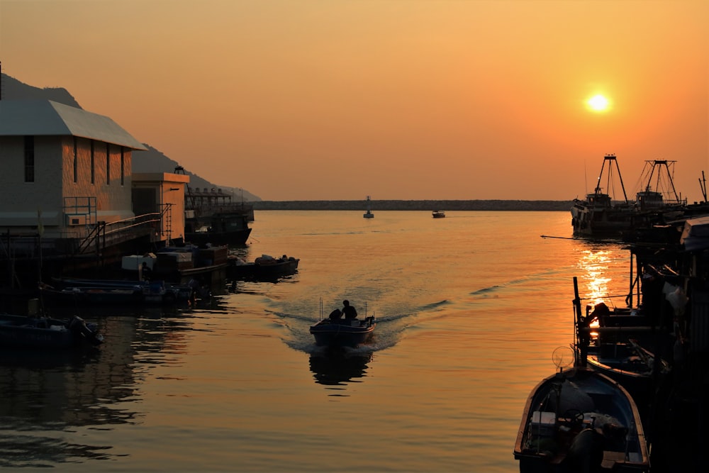 silhouette of boat on water during sunset