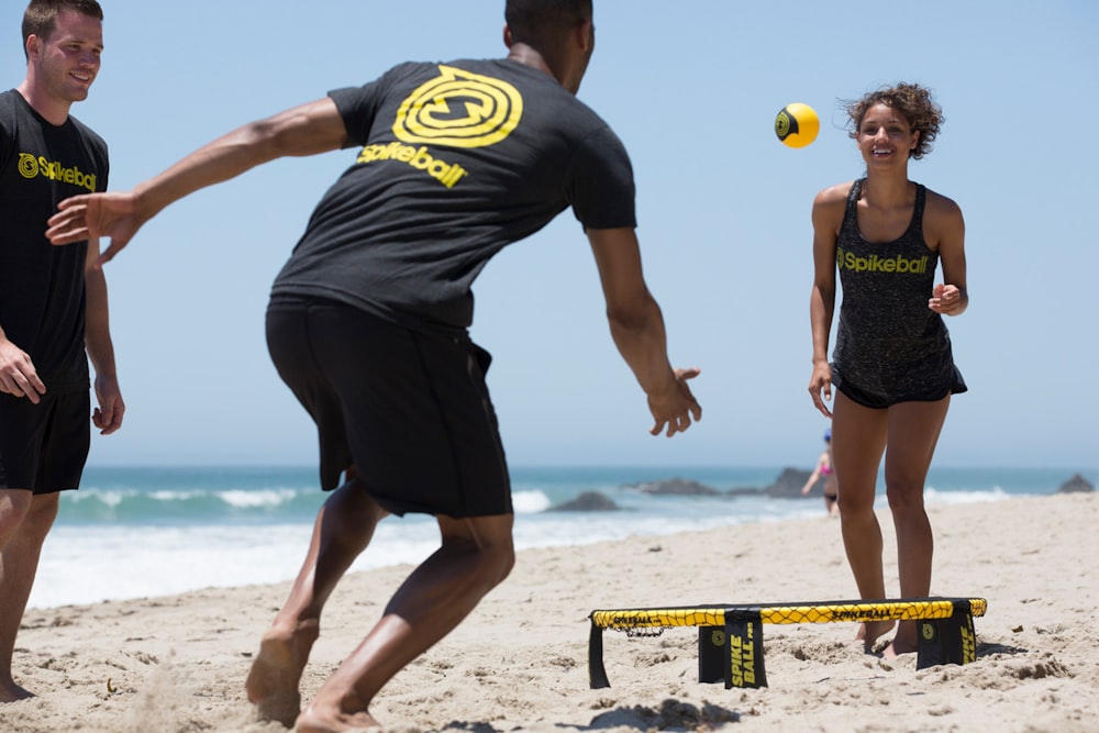 man in black and yellow nike crew neck t-shirt and black shorts standing on beach