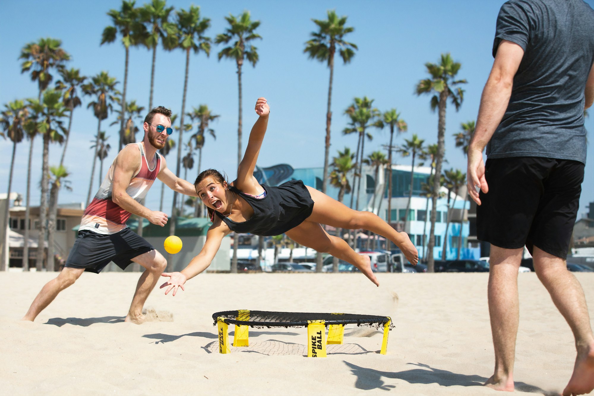 Girl diving for ball over Spikeball net on the beach