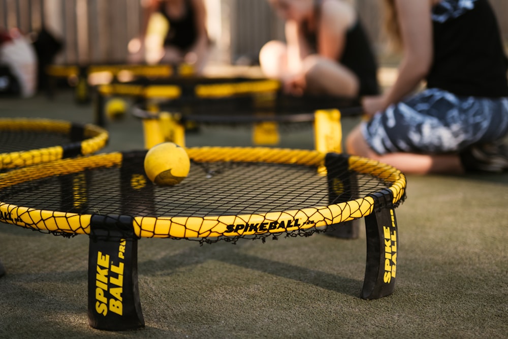 yellow tennis ball on black and yellow trampoline