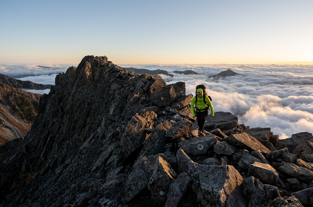 Mountaineer with backpack using climbing rope to climb rocky mountain  summit. photo – Climbing Image on Unsplash