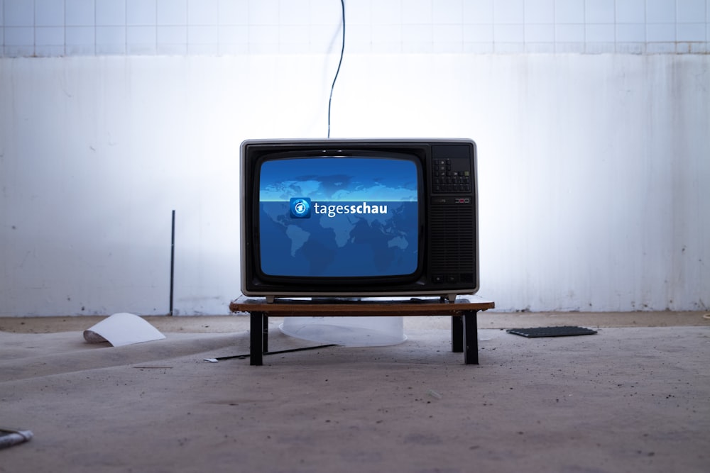 Schwarzer CRT-Fernseher auf schwarzem Holztisch