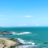 A coastal scene with turquoise waters meeting sandy shores.