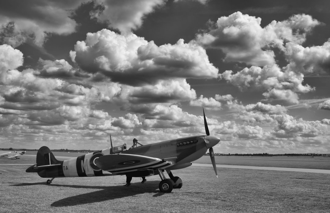 grayscale photo of fighter plane on the sky, Supermarine Spitfire waiting to take off from IWM Duxford