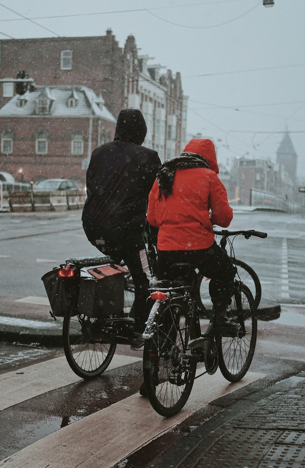 man in black jacket riding on black bicycle during daytime