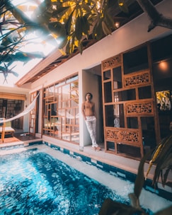 woman in white dress standing beside swimming pool during daytime
