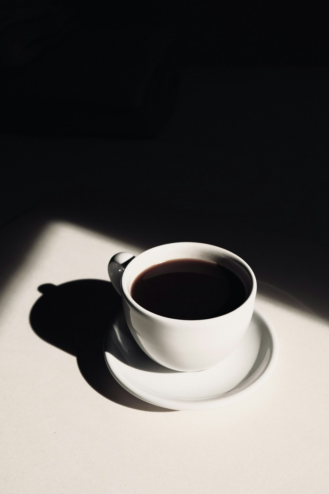 white ceramic teacup of coffee on saucer