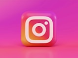 A 3D, colorful depiction of the Instagram logo, featuring a gradient background of pink and orange hues.