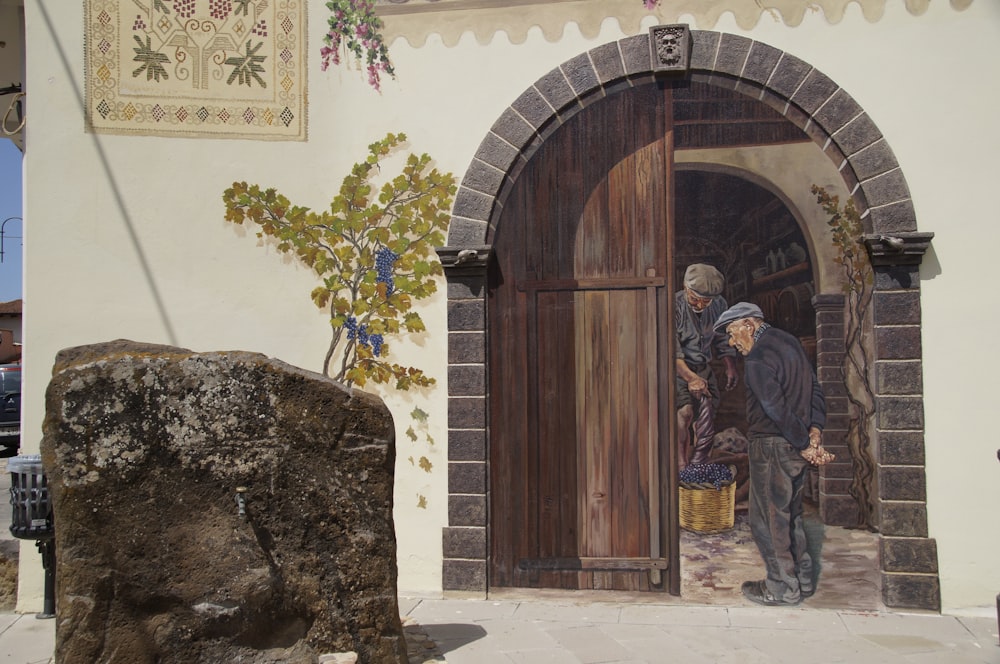 brown wooden door with man in robe statue