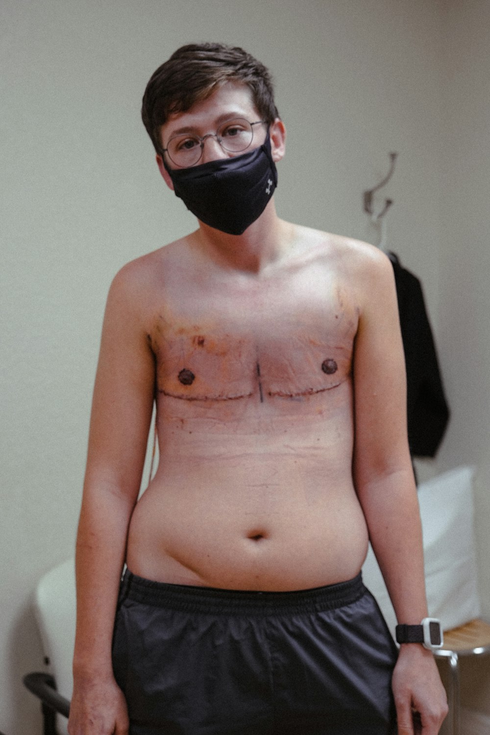 Homme seins nus portant un masque facial noir