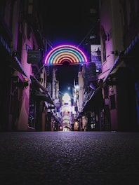 A vibrant neon-lit pathway winding through a dark urban neighborhood, symbolizing hope and direction.