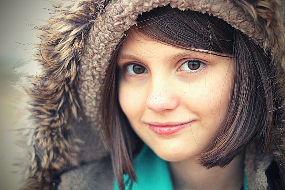 woman in green shirt wearing brown and black fur hat