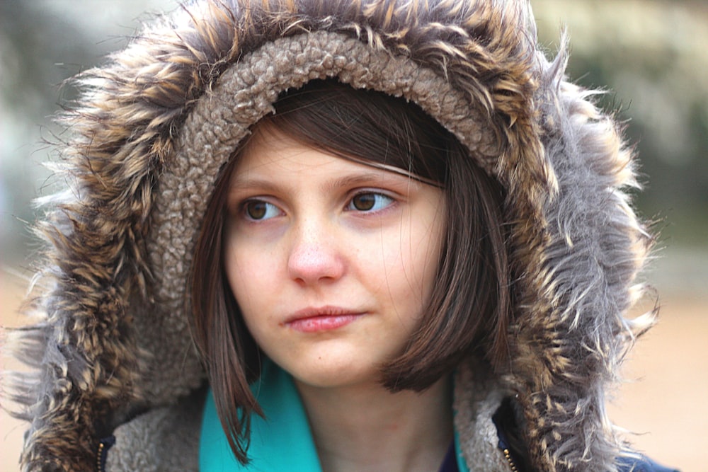 woman in green shirt and brown and black fur hat