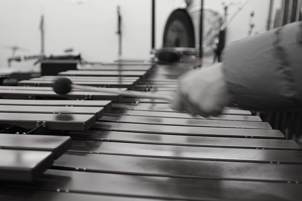 persona in camicia bianca a maniche lunghe che suona il pianoforte