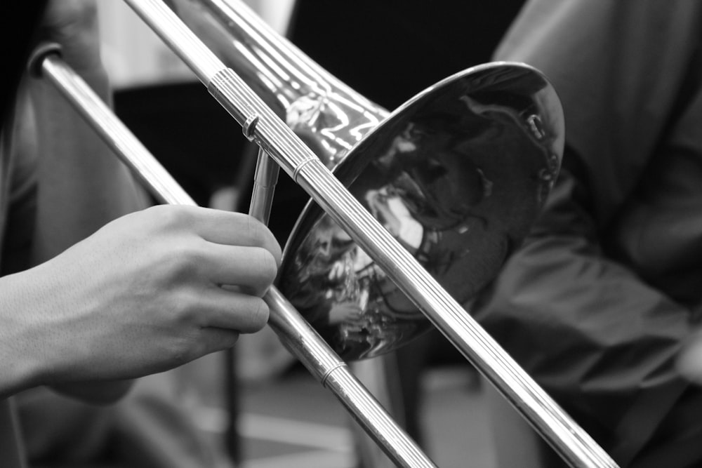 person playing trumpet in grayscale photography