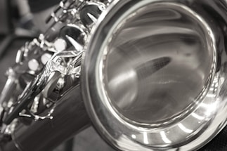 Close-up of saxophone resting on a polished wooden surface.