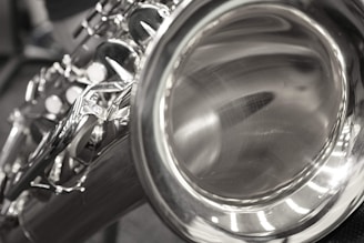 A close-up view of the bell and keys of a shiny saxophone, with a focus on the reflective metal surface and intricate keywork.
