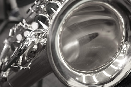 Close-up of saxophone resting on a polished wooden surface.